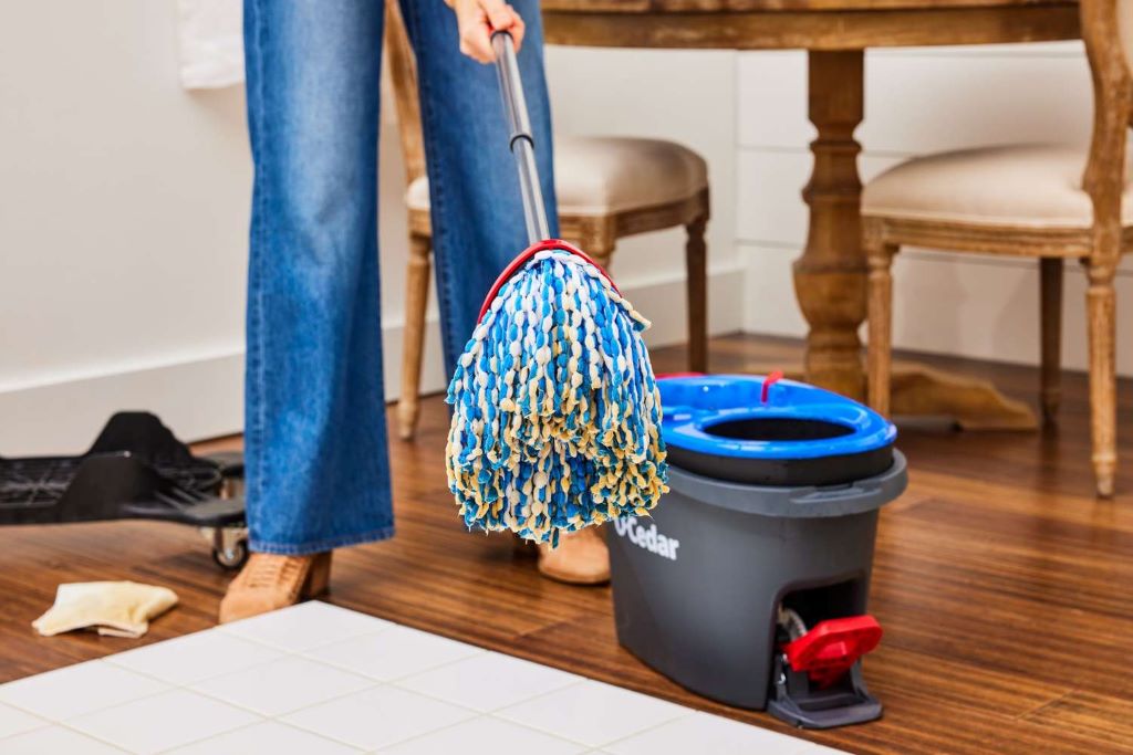 Clean O-Cedar mop head being lifted away from mop base showing proper removal technique for washing