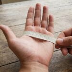 Measuring tape wrapped around a palm for glove sizing