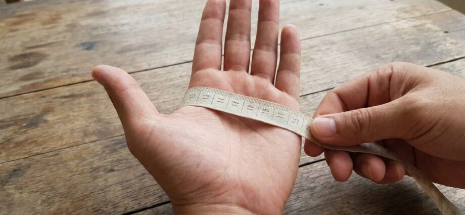 Measuring tape wrapped around a palm for glove sizing